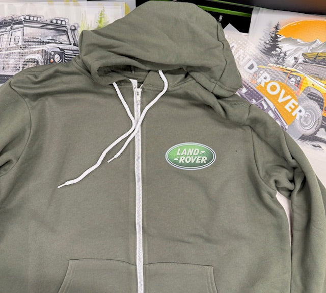 Green hoodie with Land Rover logo on a surface with printed materials in the background